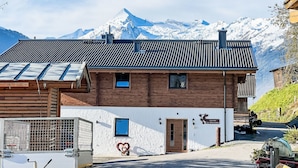 A two-story building with a sloped roof, a wooden facade, and a sign indicating it is a restaurant.