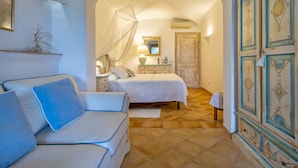 A bedroom with a bed, a nightstand, a lamp, a dresser, and a chair.
