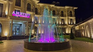 Ein Hotel mit Springbrunnen, beleuchtet von farbigen Lichtern.
