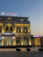 A hotel with a prominent AMETIST sign and a restaurant named AMORE MIO.