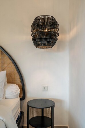 A room with a bed, a round black table, and a black hanging lamp. - Villa Hani Canggu (Canggu)