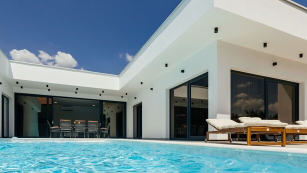 A modern house with a swimming pool, large windows, and outdoor seating. - Wonderful private villa for 10 guests with WIFI, A/C, private pool, TV and terrace (Dropuljici)