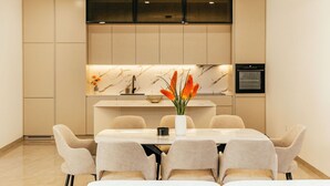 A modern kitchen with a marble backsplash, a built-in oven, and a dining area with a white table and chairs. - Wonderful private villa for 10 guests with WIFI, A/C, private pool, TV and terrace (Dropuljici)