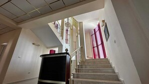 A staircase with a handrail, a black object on the left, and a door at the bottom. - Quartz Hotels Varna Briz (Varna)