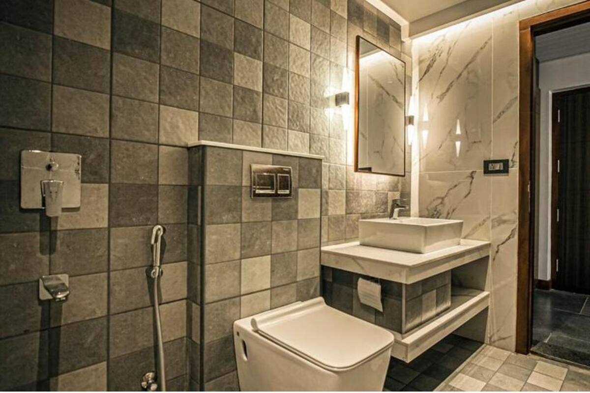 Un baño moderno con lavamanos de mármol, inodoro y ducha.