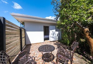 Enjoy a patio with a round table and four chairs, surrounded by lush greenery and a scenic view.
