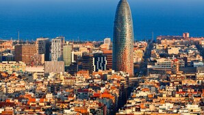 Un paisaje urbano con un moderno rascacielos destacado y edificios urbanos densos.