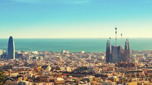 Un paisaje urbano con un rascacielos moderno destacado y una catedral histórica con múltiples agujas.