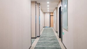 A hotel corridor with a carpeted floor, recessed lighting, and a door at the end. - GreenTree Inn Express Hotel (Yangzhou Slender West Hunan Branch) (Yangzhou)