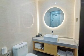 A modern bathroom with a round mirror, a sink, and a toilet. - GreenTree Inn Express Hotel (Yangzhou Slender West Hunan Branch) (Yangzhou)