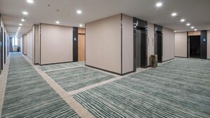 A hotel corridor with carpeted floors, recessed lighting, and doors leading to rooms. - GreenTree Inn Express Hotel (Yangzhou Slender West Hunan Branch) (Yangzhou)