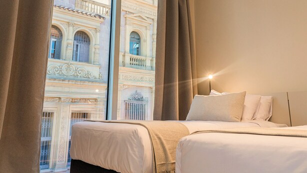 A hotel room with a large window, a bed, and a nightstand. - Triple apartment one block from the Main Sq. (Salta)