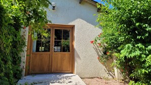 A rustic house with a wooden door and a small porch area.