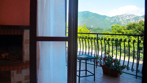 A balcony with a view of mountains, a table with a book, and a potted plant. - Casa Tramonti D Amare - On the Hills of the Amalfi Coast (Tramonti)
