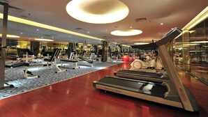 Un gimnasio moderno con cintas de correr, máquinas de pesas y pelotas de ejercicio.