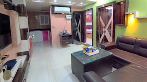 Una sala de estar moderna con un sofá, una mesa de centro de vidrio y un ventilador de techo.