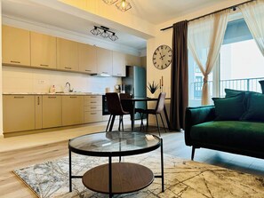 Una cocina moderna con armarios, una mesa de comedor, sillas y una mesa redonda de vidrio en la zona de estar.