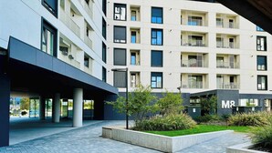 Een modern gebouw met meerdere balkons en een geplaveid binnenterrein.