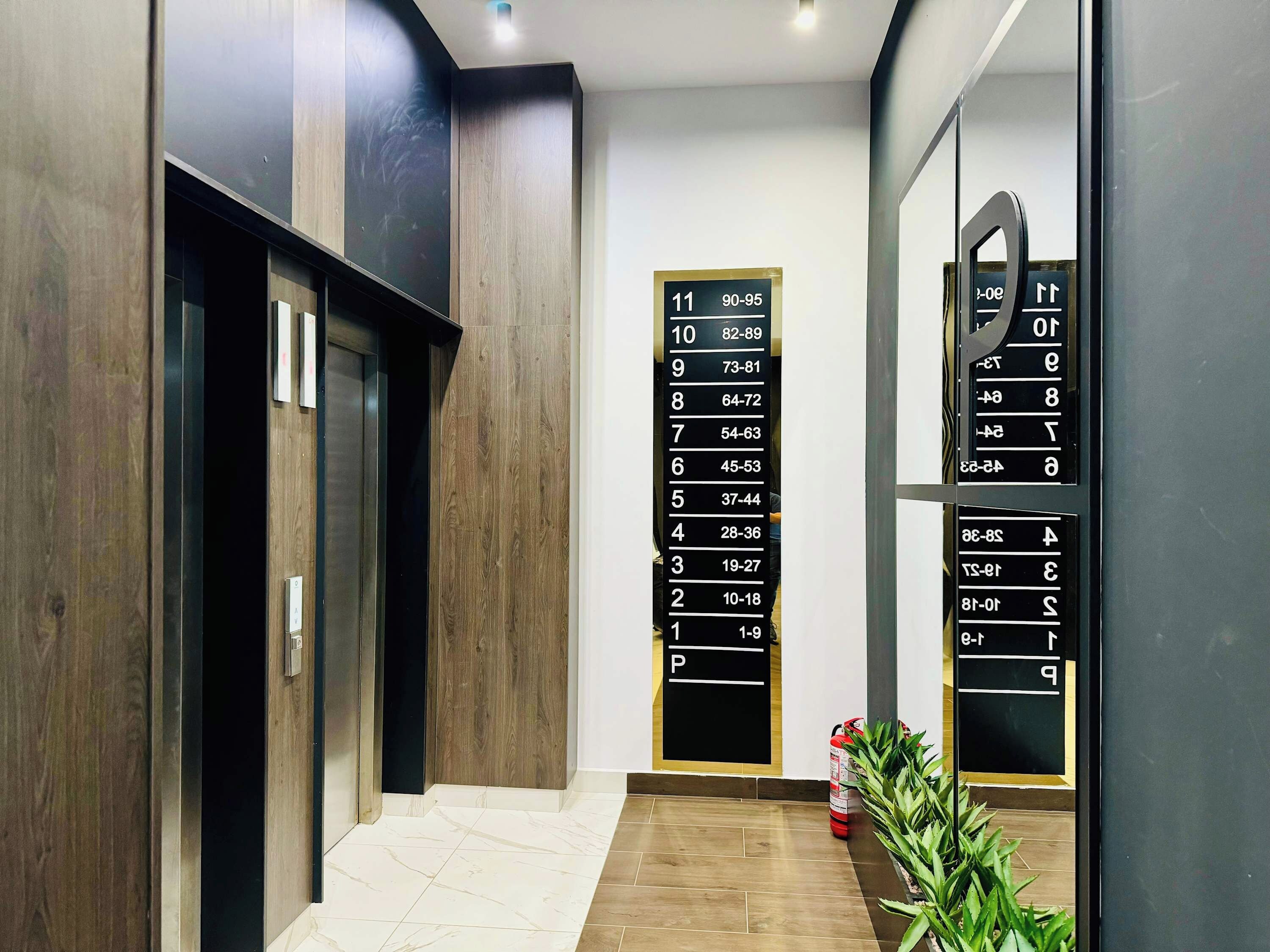 A modern elevator with a digital display showing floor numbers and ranges.