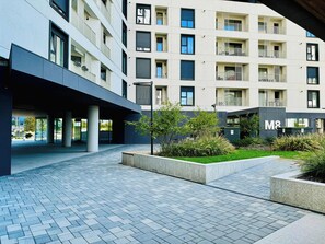 Un edificio moderno con varios balcones y un patio empedrado.