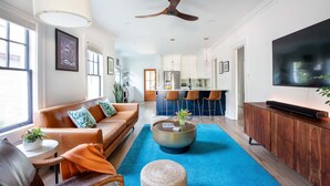 Una sala de estar moderna con sofá, mesa de centro y televisor.