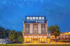 A building with a sign for a business and travel hotel.