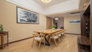 Un salón de conferencias con una larga mesa de madera, seis sillas, una lámpara de araña y obras de arte en las paredes.