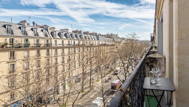 A row of townhouses with a balcony featuring two wine glasses.