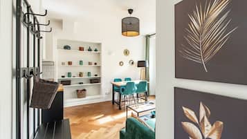 Een modern interieur met een eethoek, een trap met een mand en decoratie aan de muur.