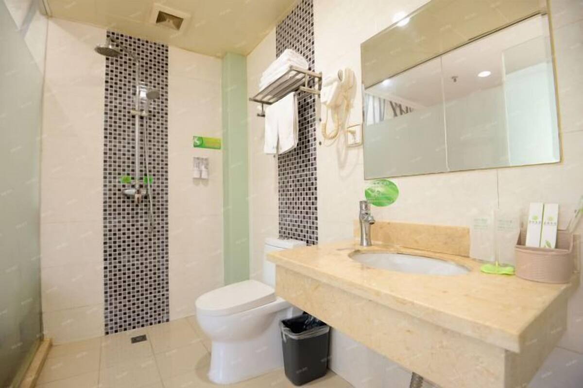 Een moderne badkamer met douche, toilet en wastafel.