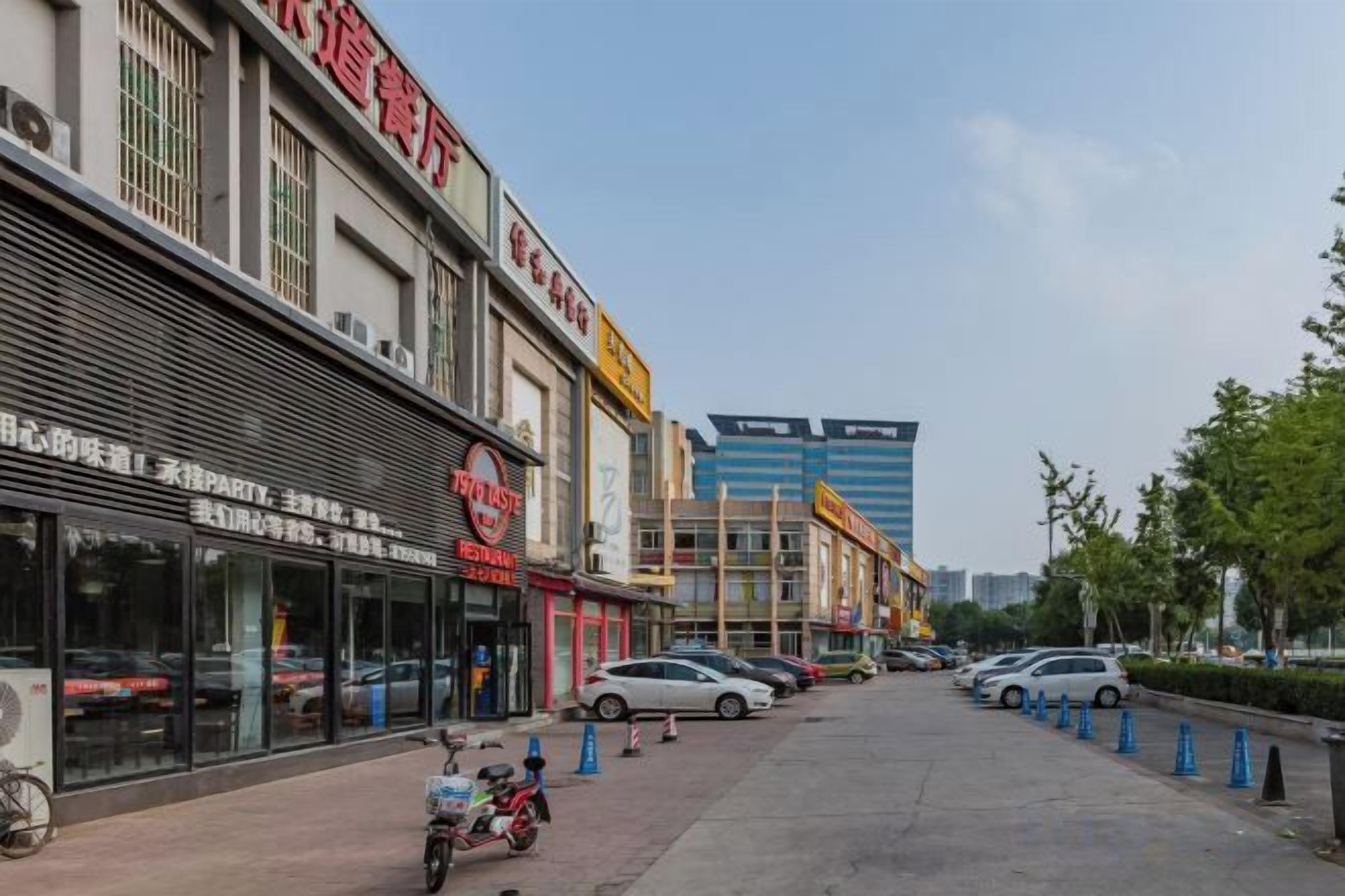 A street with parked cars and a building with a sign.