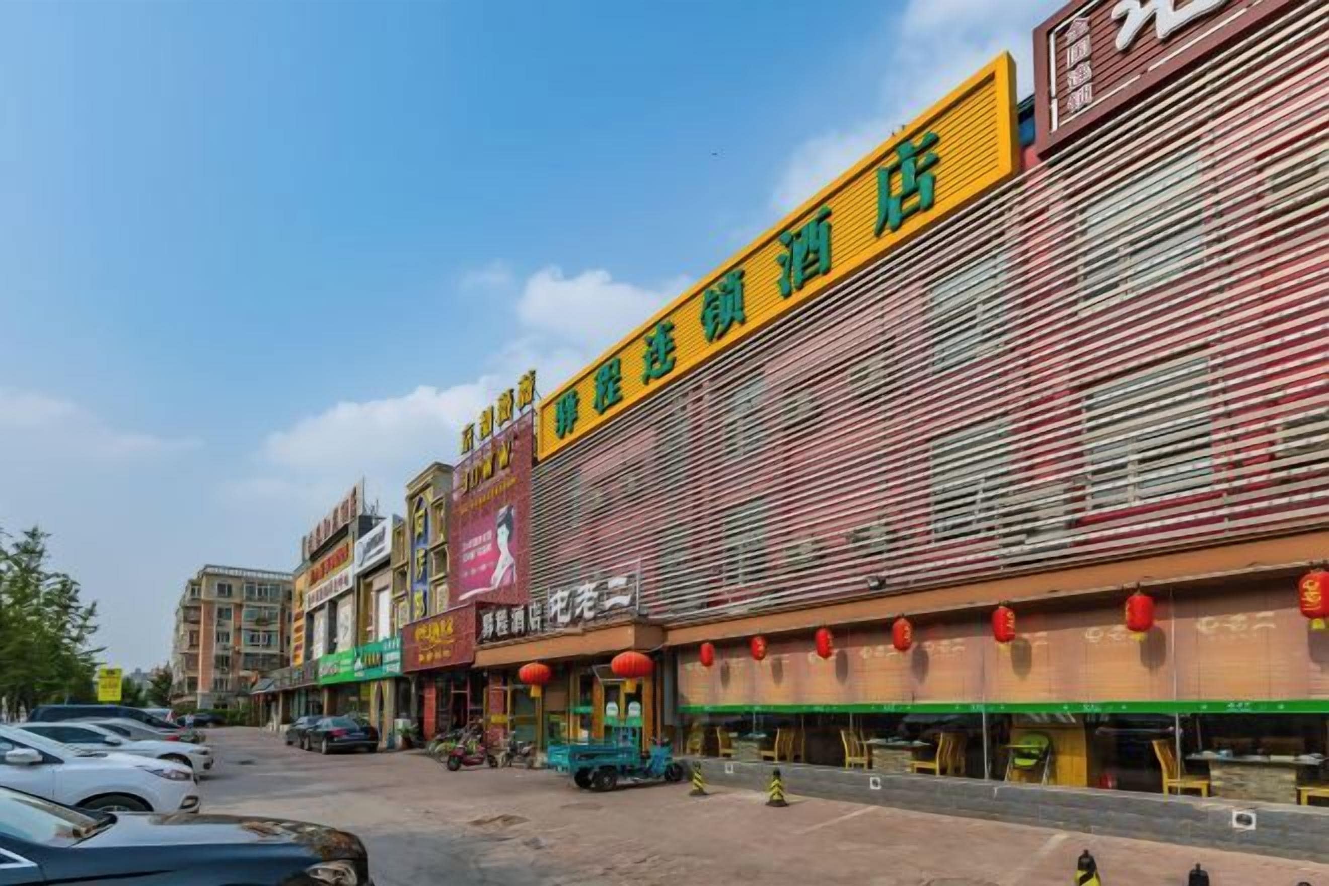 A commercial building with multiple storefronts, including a visible restaurant and a hotel.