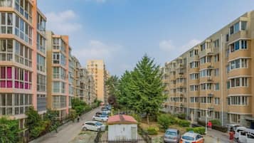 Zona residencial con edificios de apartamentos de varios pisos, un estacionamiento y un pequeño jardín amurallado.