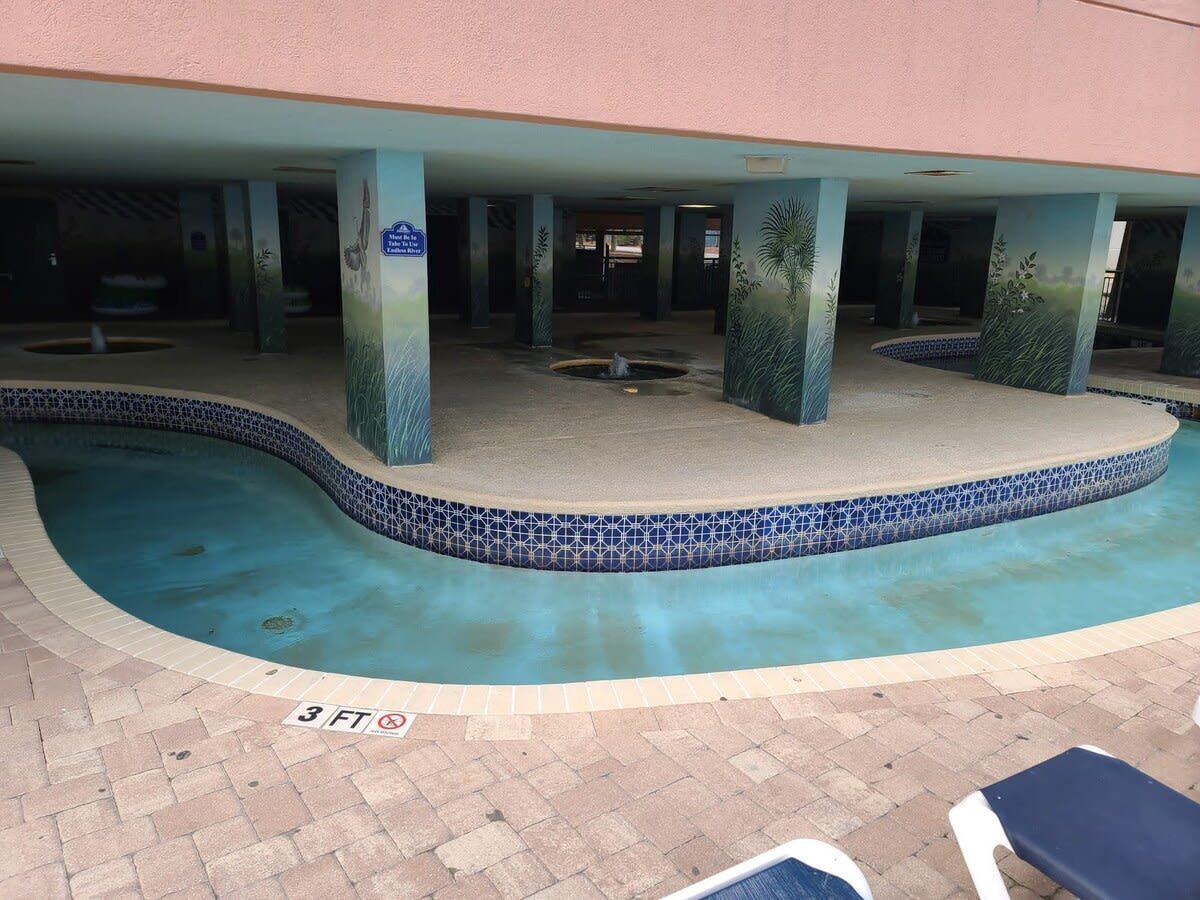 A swimming pool with a tiled edge, a 3 ft depth marker, and a sign indicating a 3 ft depth.