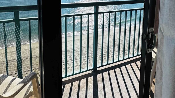 En balkon med udsigt over havet og stranden.