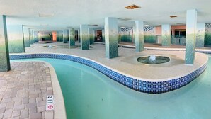En indendørs swimmingpool med flisekant, dybdemarkering på 90 centimeter og en fontæne i midten.