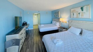 A hotel room with two beds, a desk with a chair, a mirror, and artwork on the walls. - SC5 Oceanfront beautiful condo right on the beach (Myrtle Beach)