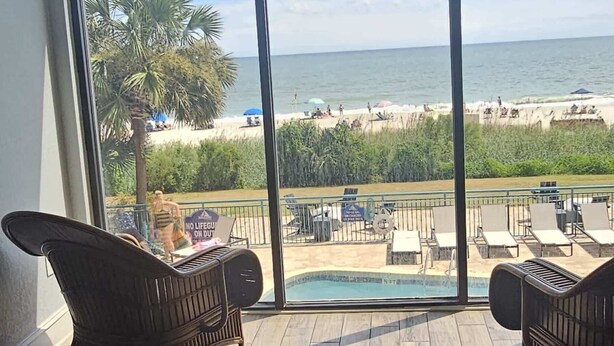 A balcony with a view of the beach and pool. - SC5 Oceanfront beautiful condo right on the beach (Myrtle Beach)