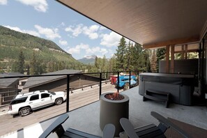 Enjoy the breathtaking mountain views from this balcony with a cozy fire pit and outdoor seating area.