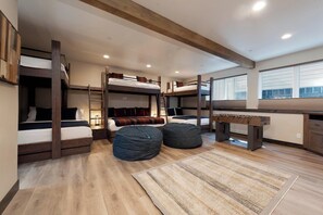 Cozy retreat with a bunk bed setup, wooden ceiling, and foosball table for a fun stay.
