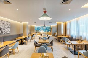 A modern restaurant with booths and tables, a large pendant light, and a city view. - Homeinn · neo (Tianjin Railway Station Binjiang Avenue Pedestrian Street) (Tianjin)