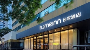 Une façade d’hôtel moderne, dotée de grandes fenêtres en verre et d’une enseigne bien visible.