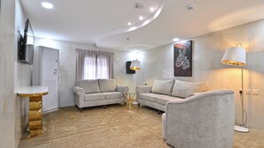 A modern living room with two sofas, a coffee table, and a lamp. - Diyar AlSaliheen Serviced Apartments (Madinah)