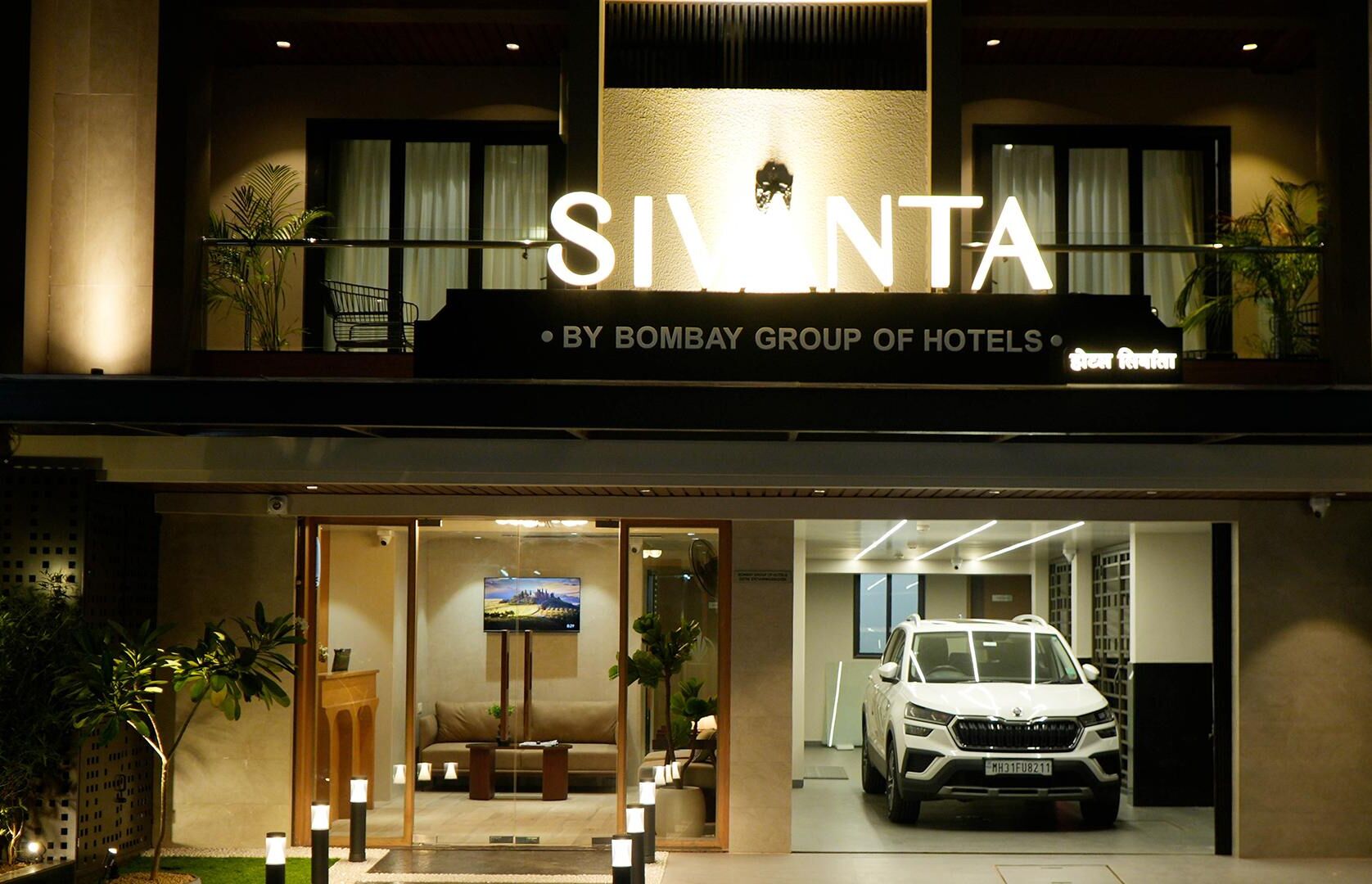 Exterior del hotel Sivanta, del grupo Bombay Hotels, con un diseño moderno que destaca una entrada principal, una zona de recepción y un espacio para estacionamiento.