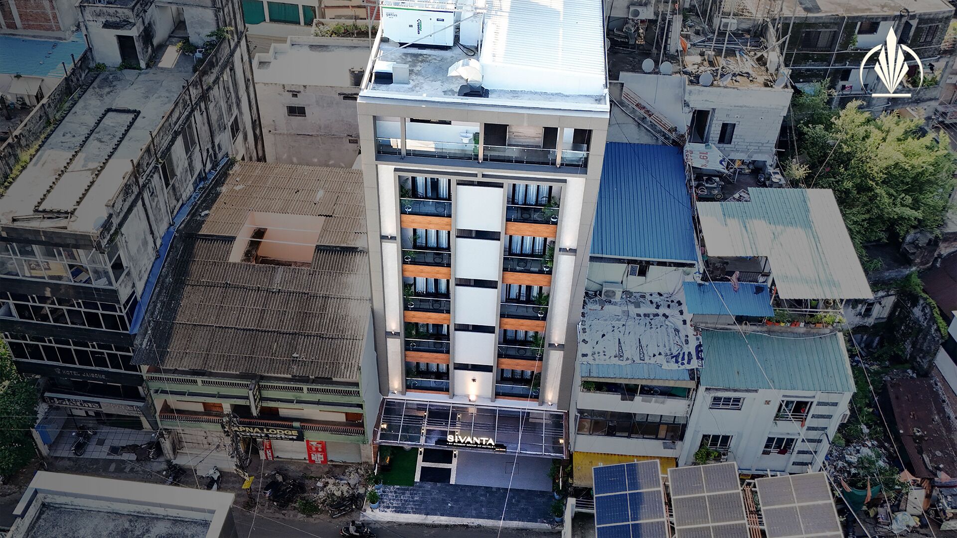 Un hotel de varios pisos con un atrio central, balcones y una terraza en la azotea.