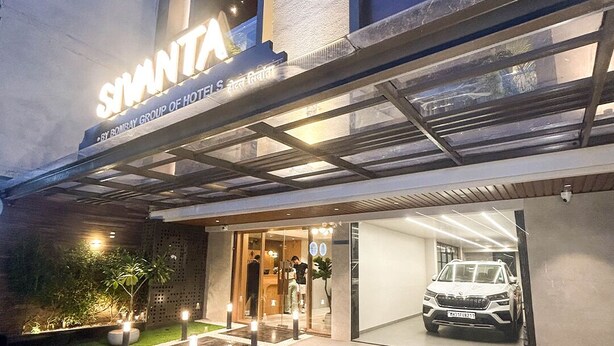A hotel entrance with a covered driveway, a car parked inside, and a well-lit facade. - SIVANTA BY BOMBAY GROUP OF HOTELS NAGPUR (Nagpur)