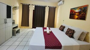Habitación de hotel con cama, armario, escritorio y aire acondicionado.