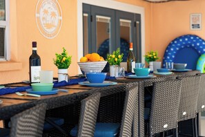 A dining table set with various dishes, a bottle of wine, and decorative plants.