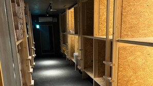 A corridor with wooden shelving units on both sides, leading to a door at the end. - YOUTEI2 (Rusutsu)