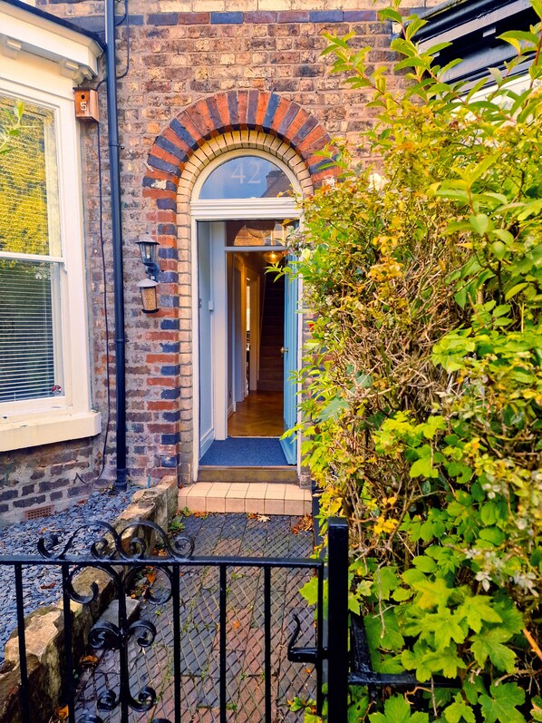 Stunning brick facade with a charming arched entrance and beautifully manicured garden.